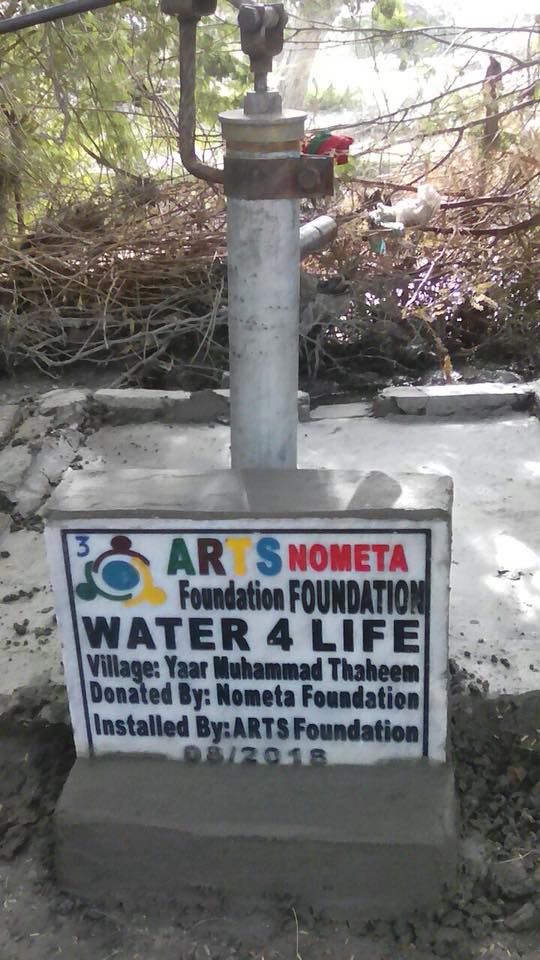 A completed hand pump beside a tree in Mirpur Khas